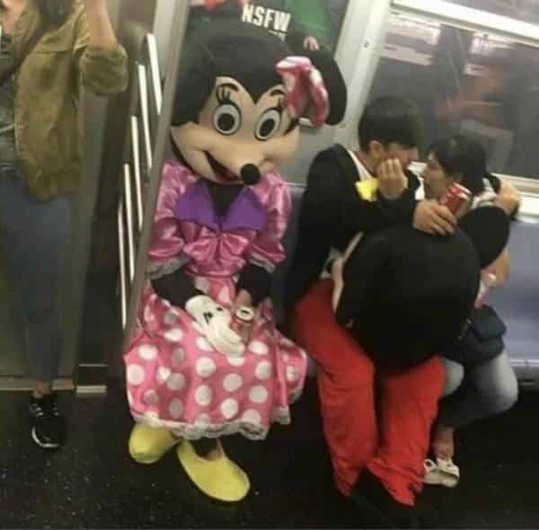mickey couple making out on subway next to Mickey Mouse