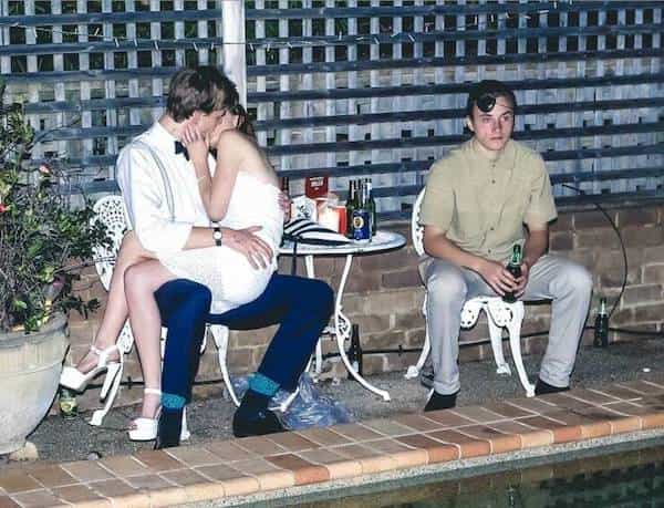 alone guy next to pool next to couple making out