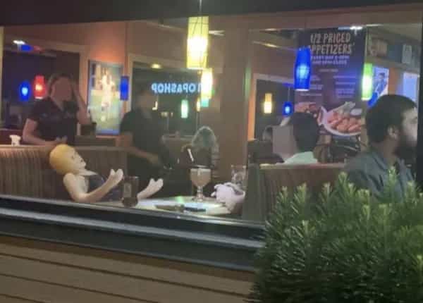 man on date with blowup doll at restaurant