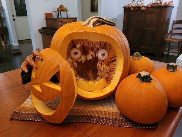 best pumpkin carving design pulling off face with eyeballs inside