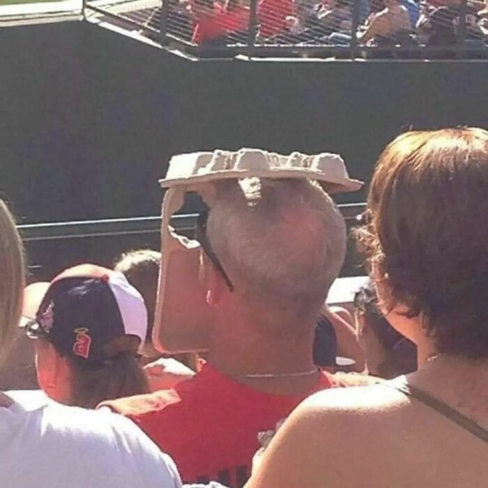 Weird Hats beer carton on guys head at baseball game