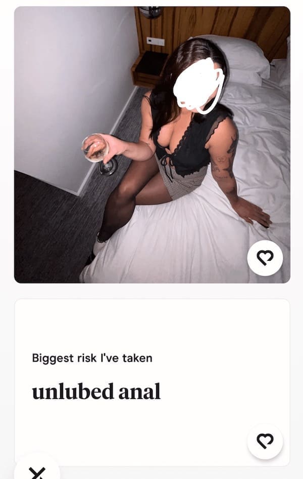 Woman holding wine on bed with shocking Hinge profile confession