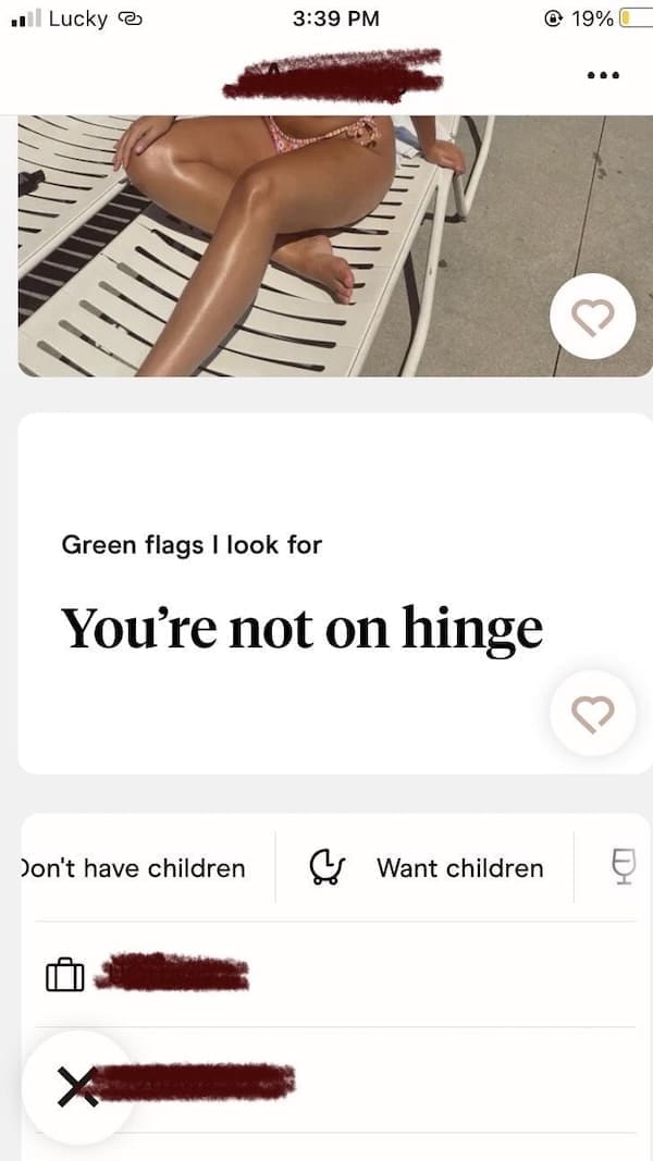 Woman sunbathing in bikini with ironic Hinge green flag about not being on Hinge