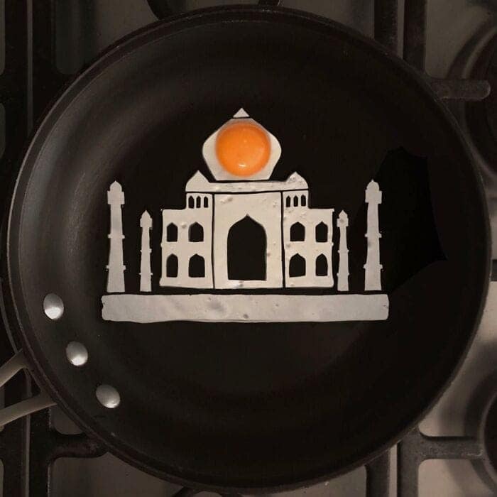 Fried egg shaped like the Taj Mahal on a black frying pan
