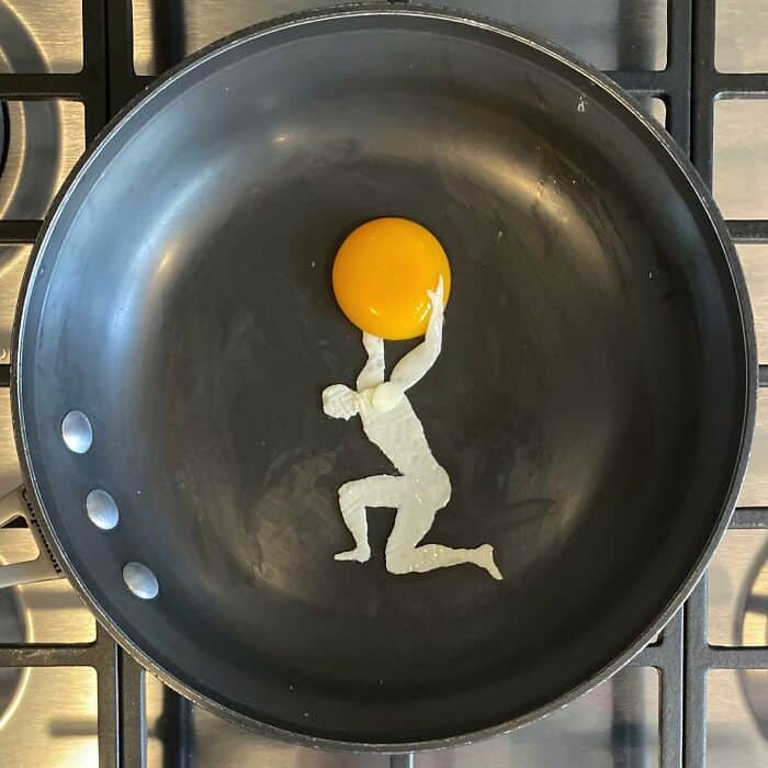 Egg white figure holding up a yolk like Atlas lifting a globe