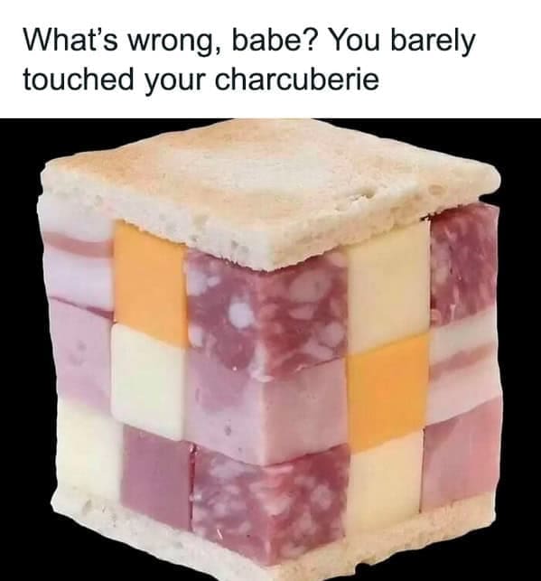Meat and cheese cubes stacked like a Rubik’s Cube between bread slices.