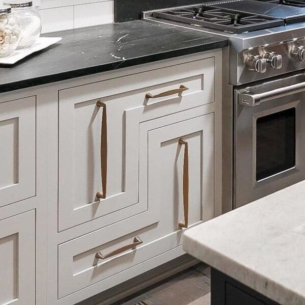 Misaligned drawer handles form an abstract maze on a modern kitchen cabinet