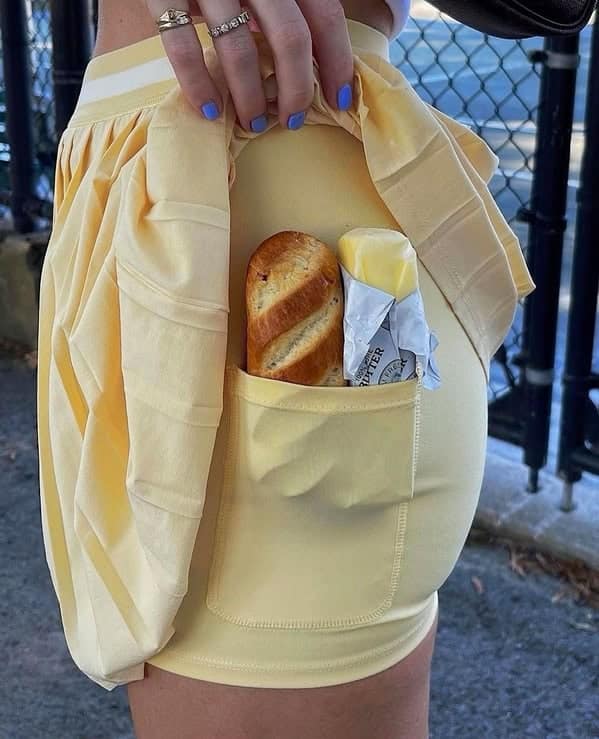 Girl with baguette and butter in shorts pocket