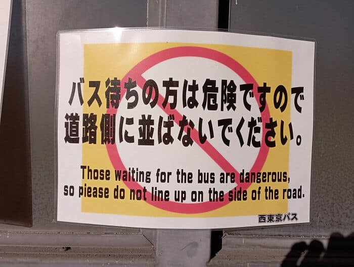 Bus stop warning sign with accidental insult