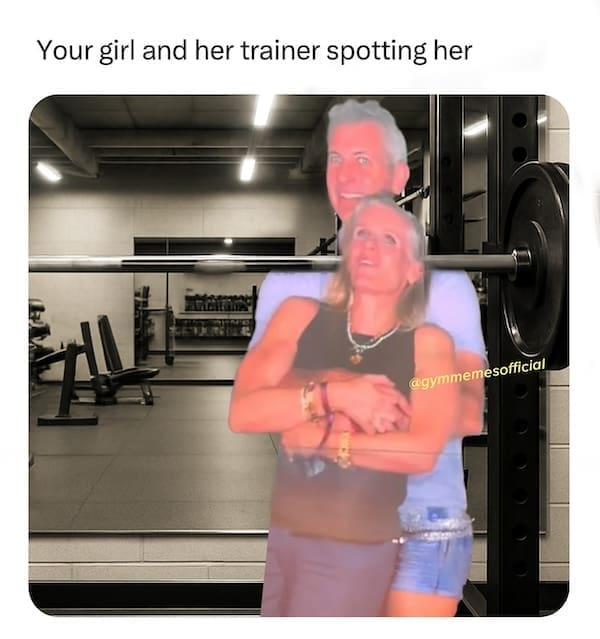 Personal trainer hugging woman while spotting her at the gym