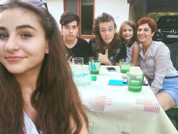 Family selfie with a young man looking like singer Harry Styles.