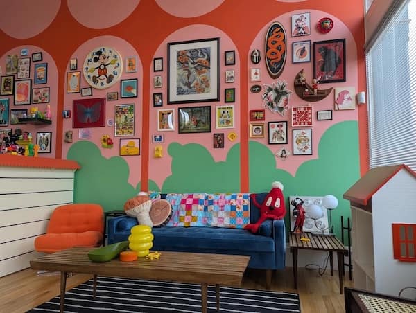 Eclectic living room with mural walls, pop art, and cartoon decor