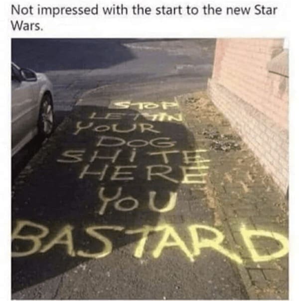 Graffiti on a sidewalk saying “Not impressed with the start to the new Star Wars” with spray-painted complaints.
