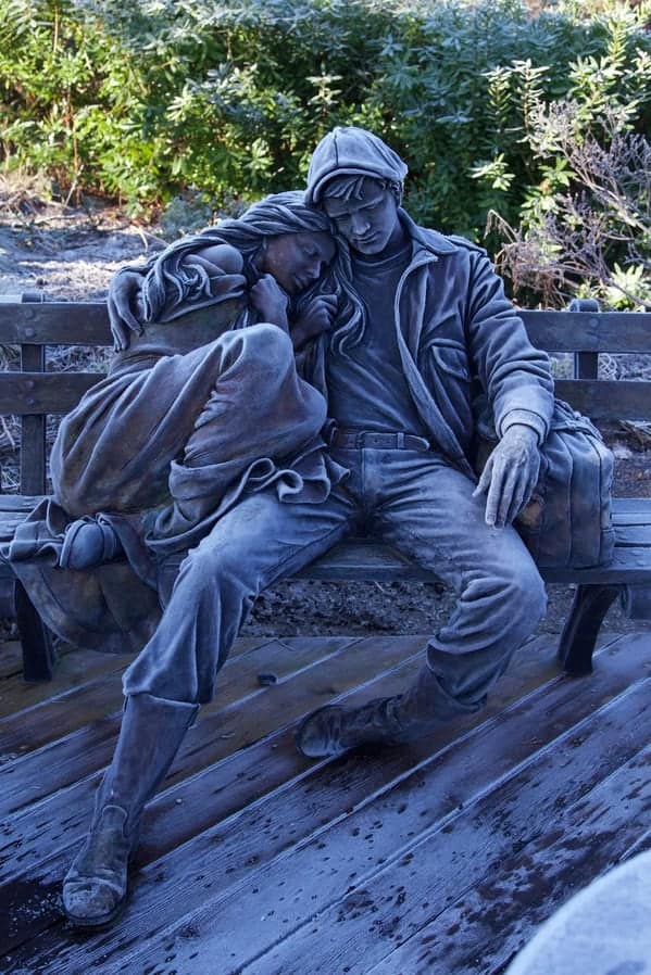 Hyper-realistic statue of a couple asleep on a park bench
