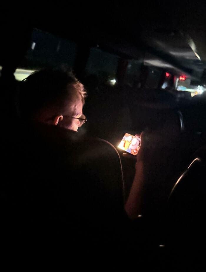 Man watching explicit content on phone during bus ride.