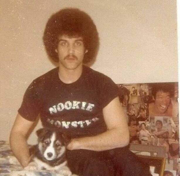 Man with afro wearing “Nookie Monster” shirt sits with puppy