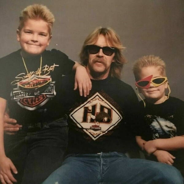 Dad and two sons with spiked blonde hair and Harley-Davidson shirts pose together