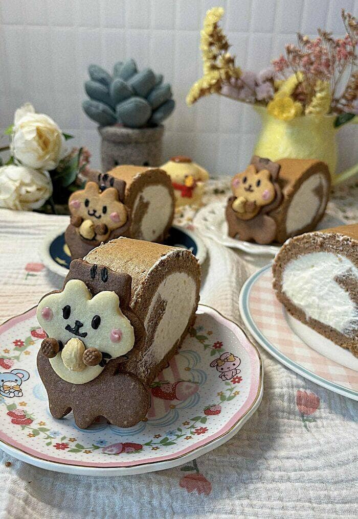 Cute squirrel-themed Swiss roll slices with cookie faces on floral plates.