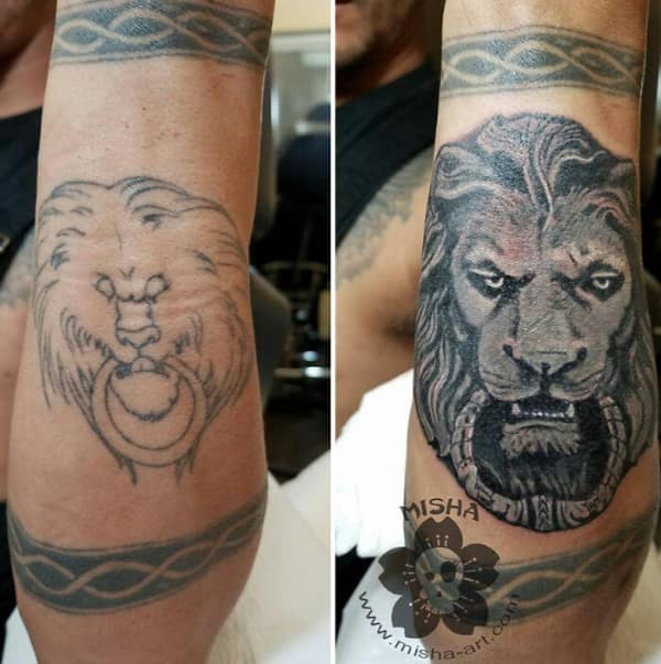 Realistic lion head forearm tattoo cover up with intense gaze and bold shading.