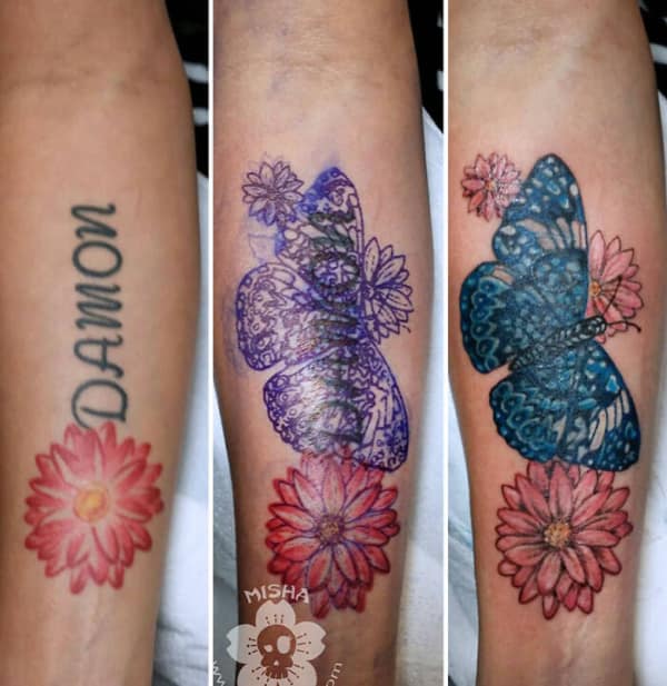 Blue butterfly and flowers forearm tattoo cover up replacing name lettering design.