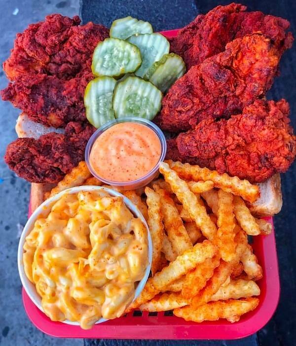 Basket meal with spicy fried chicken, crinkle fries, mac and cheese, pickles, and dipping sauce.