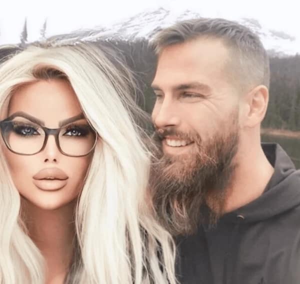 A man with a beard next to a woman with a heavily photoshopped and edited face.