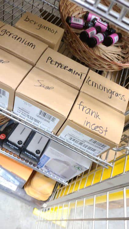 Boxes of essential oils labeled with scents like “lemongrass,” “peppermint,” and one hilariously labeled “frank incest.”