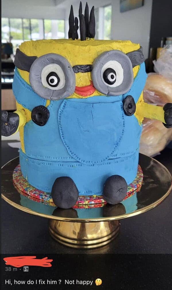 A lumpy Minion-themed cake with uneven proportions and unsettling eyes, looking more haunted than animated.