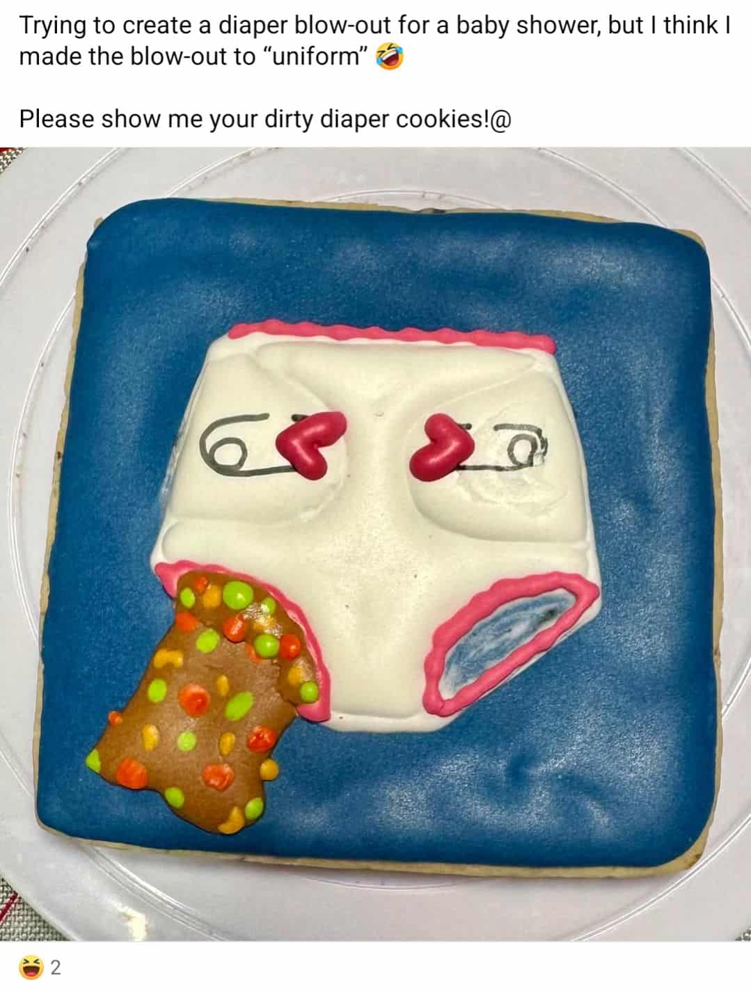 A decorated cookie of a diaper blowing out a neat pile of multicolored “poop” with cartoon eyes and hearts.