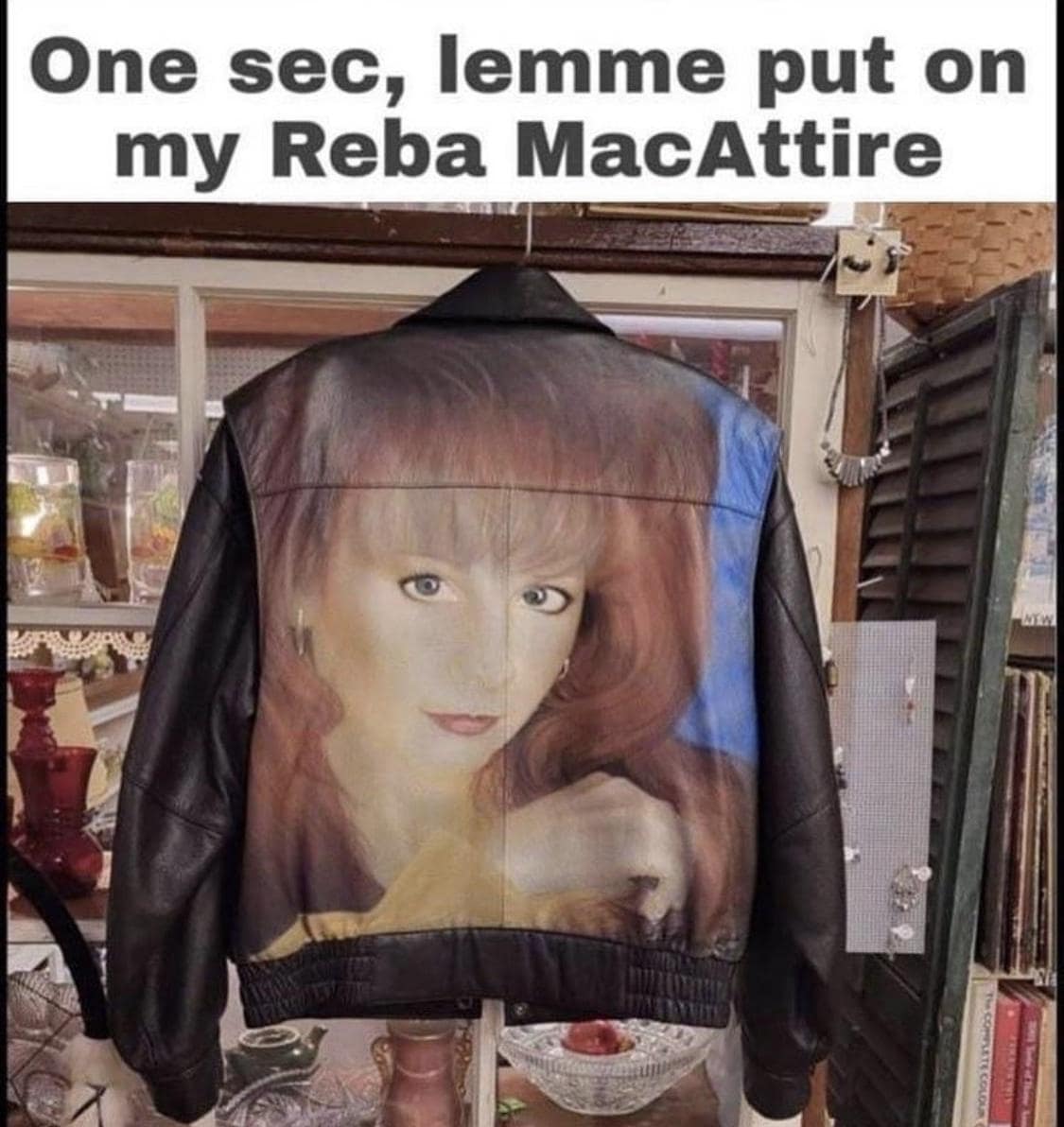 Leather jacket airbrushed with a red-haired country singer’s face; caption reads “One sec, lemme put on my Reba MacAttire.”