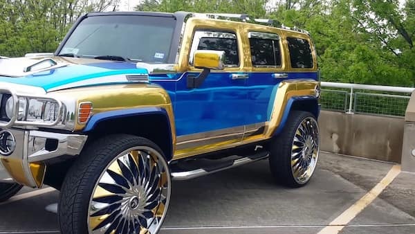 cursed cars with shiny blue and gold hummer and oversized rims