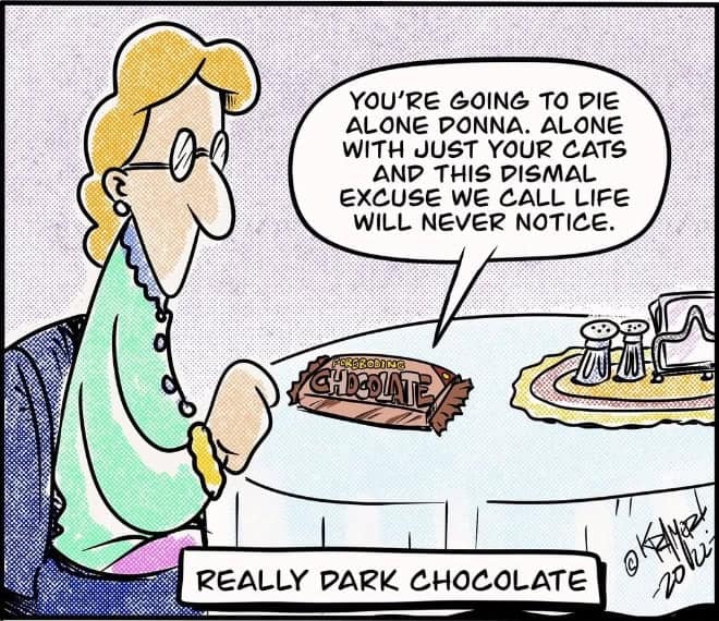 Woman sits at a table staring at a chocolate bar that insults her existence