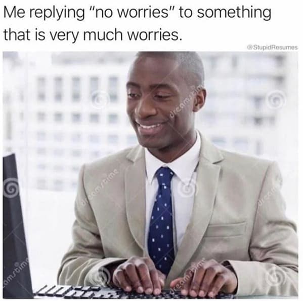 A dark humor work meme of a man smiling while typing "no worries" to a very stressful work email.