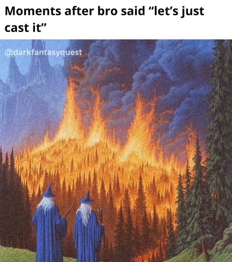 Two blue-robed wizards watch a forest accidentally erupt in flames after a miscast spell