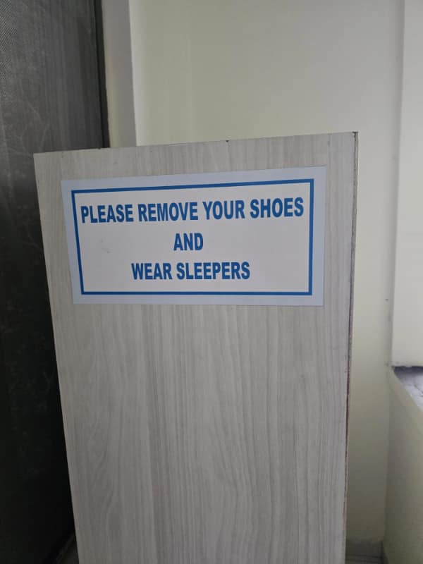 Instruction sign by a doorway