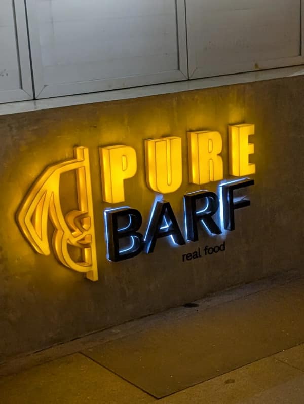 Illuminated restaurant sign with unfortunate word choice