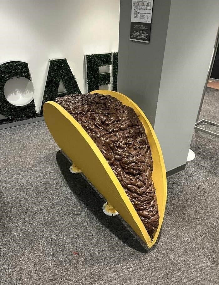 A giant taco sculpture where the brown meat filling looks disgusting and unappetizing.