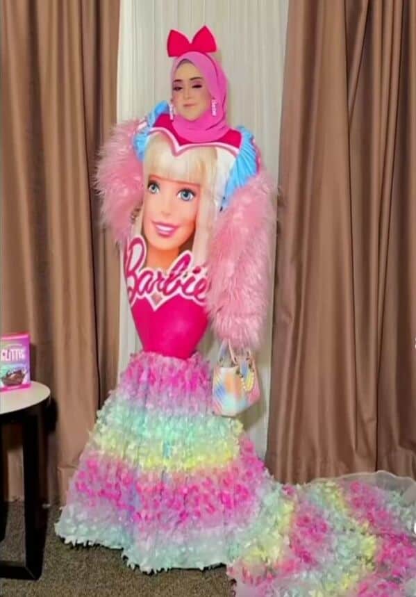A woman wearing an elaborate Barbie doll dress with a rainbow skirt, a major fashion fail.