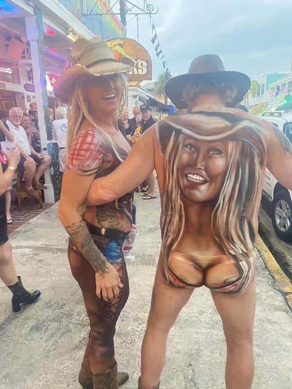 Couple in body paint with woman’s face on man’s back