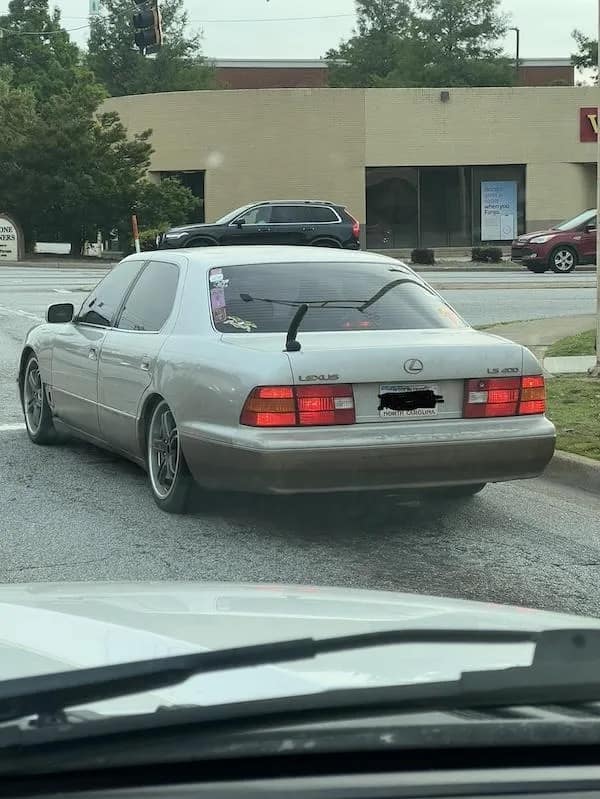 A funny meme of a nice Lexus sedan with a hilariously tiny and useless performance spoiler on the trunk.