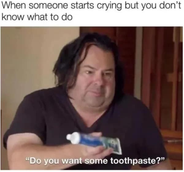 Man awkwardly offering toothpaste to someone crying