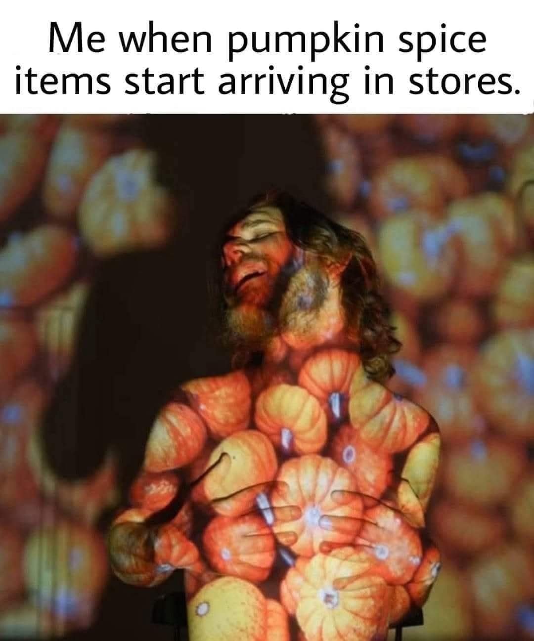 Man joyfully covered in projected pumpkins for pumpkin spice meme