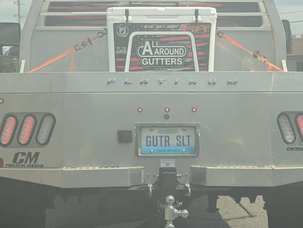 An unfortunate vanity license plate for a gutter company that hilariously reads "GUTR SLT" (Gutter Slut).