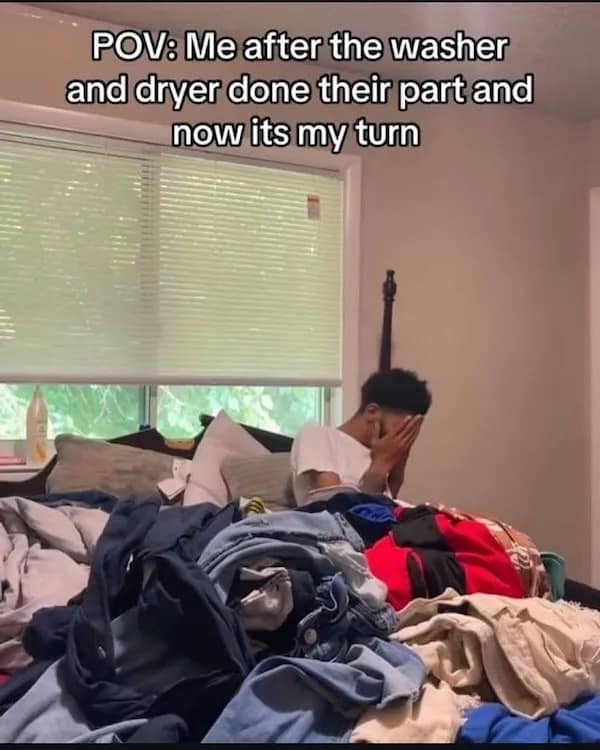 Man stressed sitting in pile of unfolded laundry with caption about post-laundry fatigue