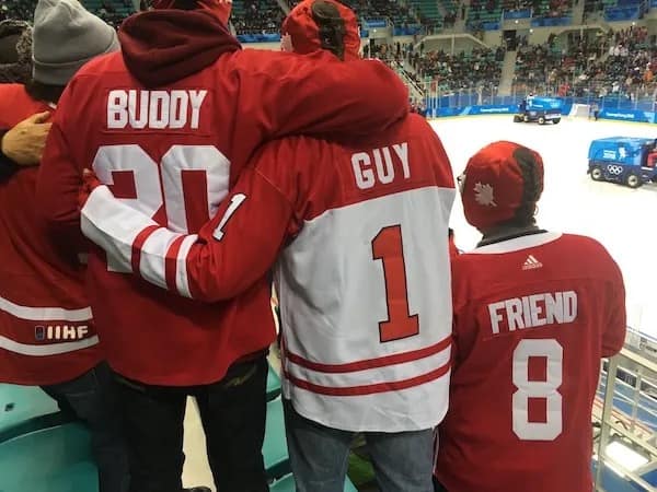 Friends wearing red hockey jerseys labeled Buddy, Guy, and Friend