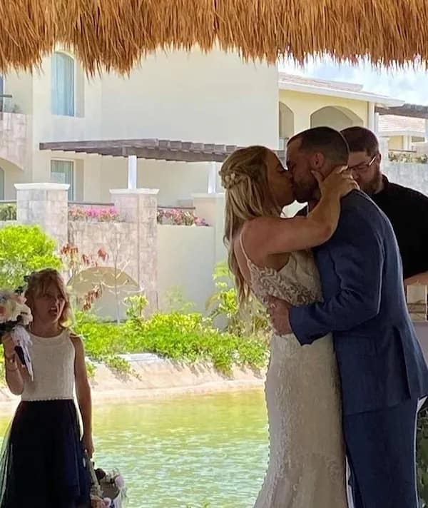 A funny pic of a flower girl making a disgusted face during the wedding kiss.