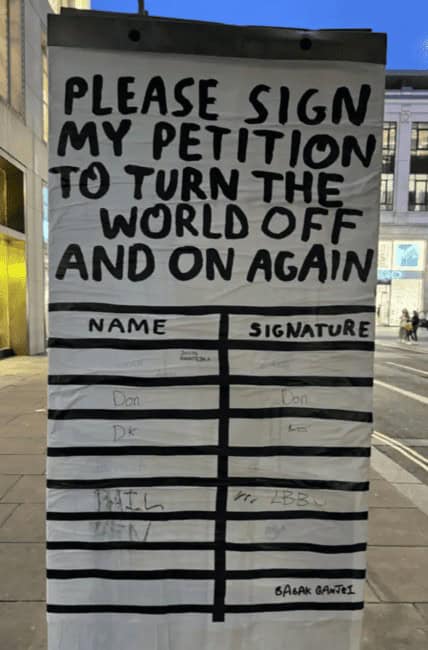 Street poster asks people to sign a petition to “turn the world off and on again.”