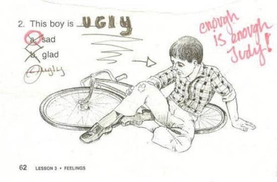 Worksheet image of a boy by a fallen bike; student writes “ugly,” teacher scolds in red: “Enough is enough, Judy!”