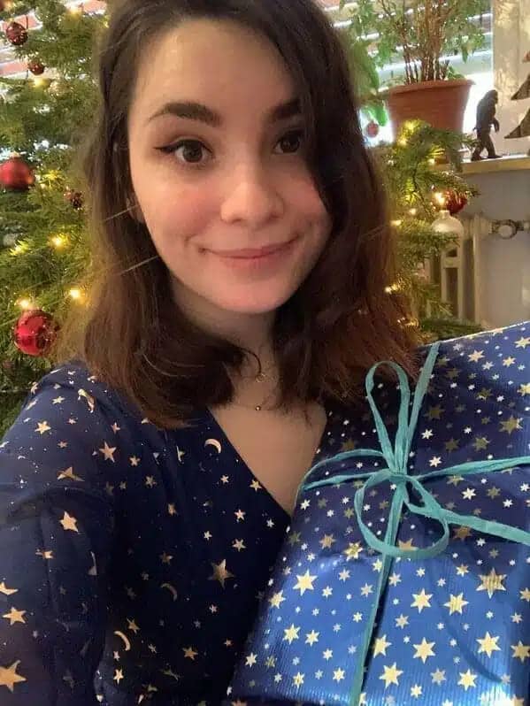 Woman in navy star-print dress holding a matching starry present
