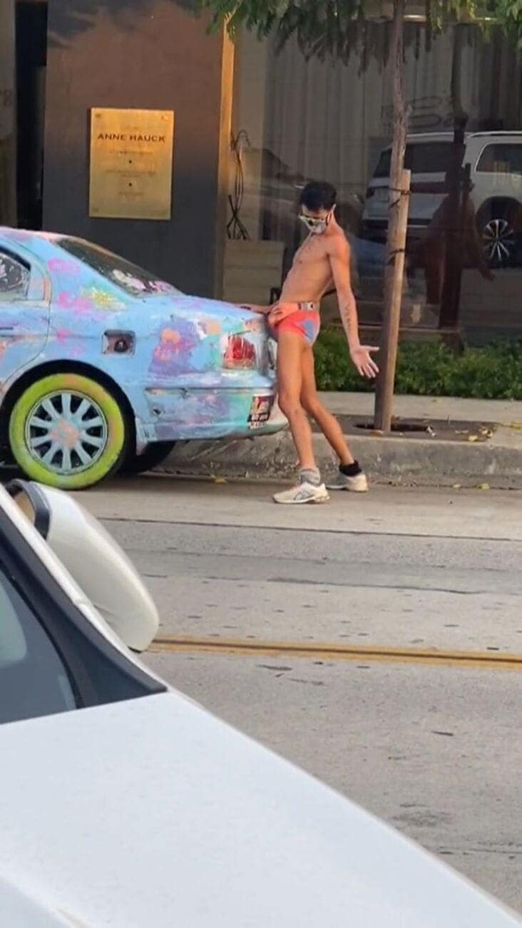 An influencer getting busted doing a cringe-worthy and suggestive photoshoot with an old car.
